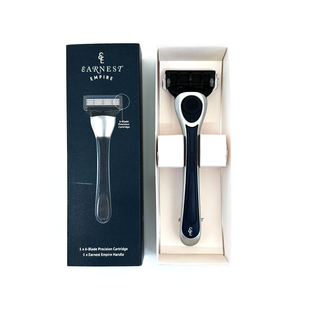 Earnest Empire navy and silver razor in its open white packaging beside the branded navy box.