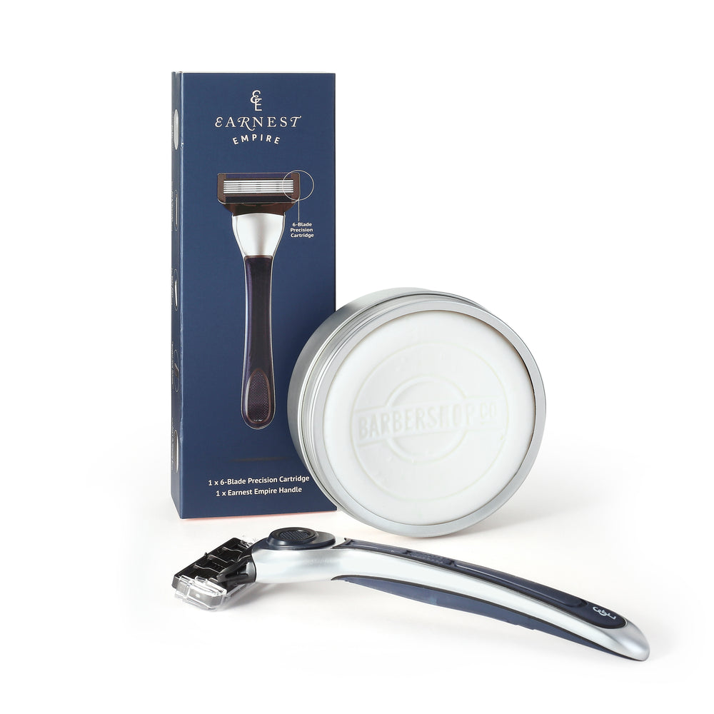 Earnest Empire razor lying in front of its navy box and BarberShopCo shave soap in an open silver tin.